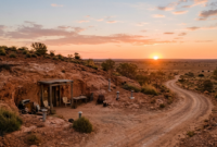 Coober Pedy's Underground Homes in the Australian Outback Coober Pedy underground dugout home entrance carved into a sandstone hillside at sunset